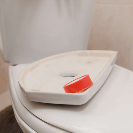 Plumber tools and equipment in bathroom lying on toilet lidの写真素材