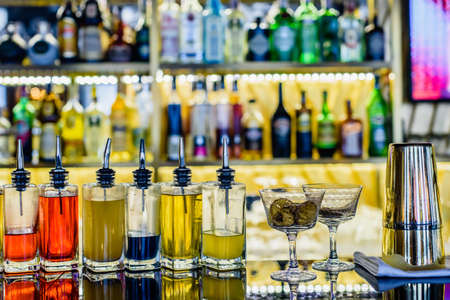 Various bottles of alcohol drinks on counter in modern restaurant