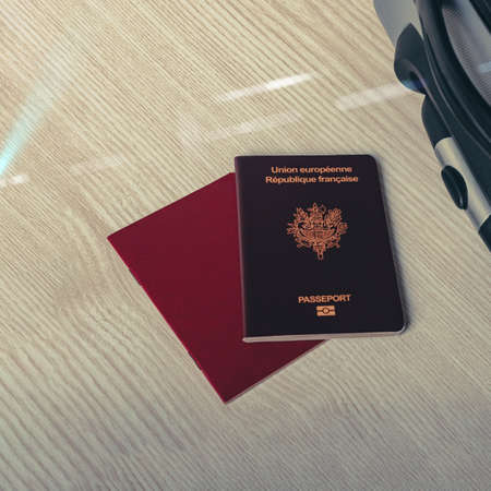 Flat lay composition with suitcase and french passport on wooden backgroundの写真素材