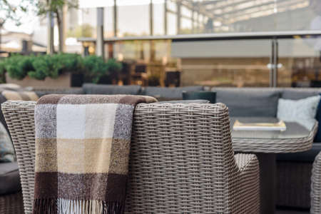 Empty terrace with comfortable armchair and warm plaid in modern restaurantの写真素材
