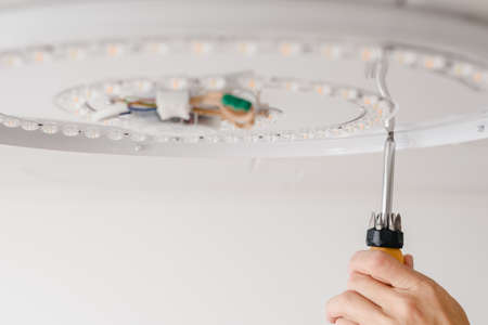 installation of a ceiling LED lamp on a screwの写真素材