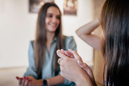 Happy smiling women talking emotionally in cafe and showing signsの写真素材