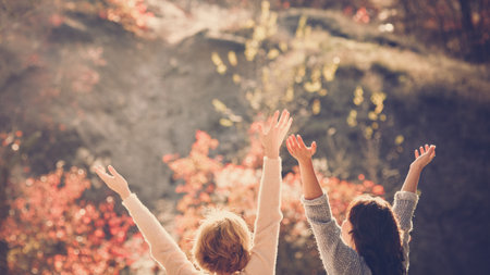 Two happy female friends enjoying golden autumn fall on sunny dayの写真素材