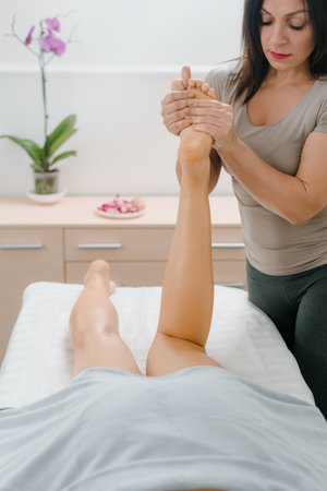 female having professional legs massage in spa salonの写真素材