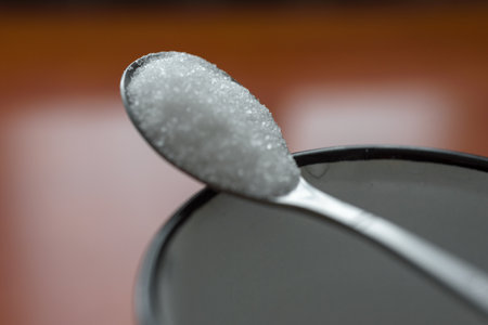 Detailed closeup shot of portion of white sugar in spoonの写真素材