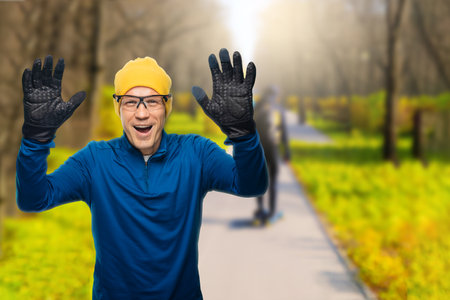 Young happy male athlete running on road in autumn park during marathonの写真素材