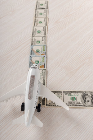 composition with airplane model and dollar banknotes on white wooden tableの写真素材