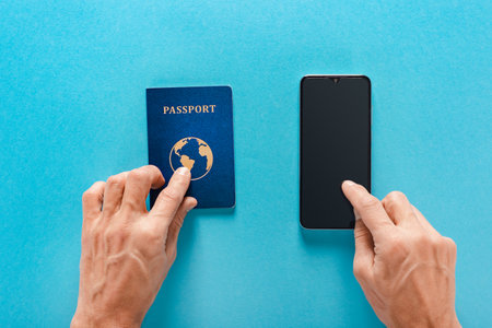 Male tourist with international passport and smartphone with travel app for buying tickets onlineの写真素材