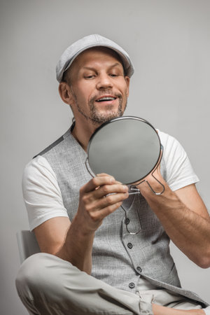 Handsome stylish positive man looking at mirror and checking shavennessの写真素材