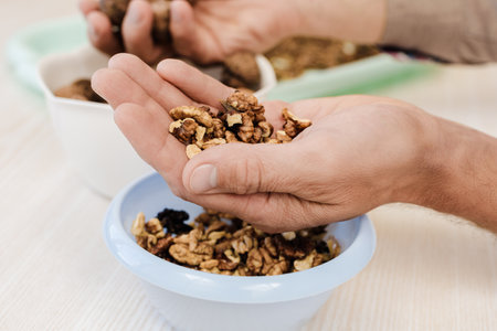 Organic tasty peeled walnuts lying on palm of young manの写真素材
