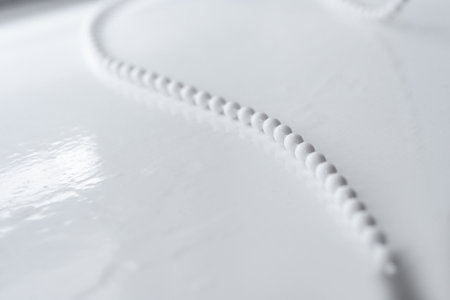 Fashionable white string of pearls lying on white backgroundの写真素材