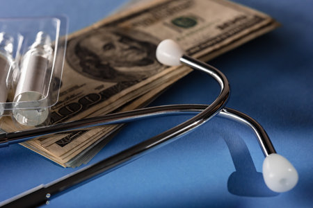 Calculating cost of medical care with stethoscope and ampoules on blue backgroundの写真素材