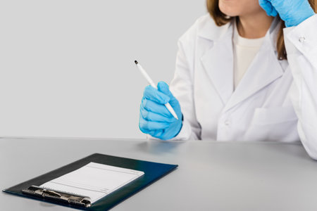 Closeup photo of female pharmacist and prescription for pills on studio gray background