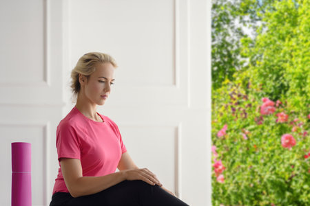 Calm beautiful relaxed woman doing yoga on summer terrace with garden viewの写真素材