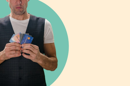 Closeup of young man showing different credit cards, Hands full of options: Man holds a variety of...