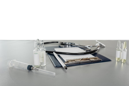 ampoule syringe and stethoscope lying on an empty prescription form on a gray table with copy space backgroundの写真素材