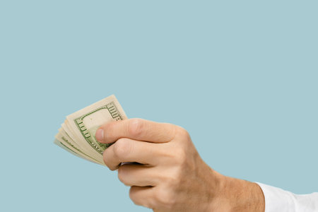 Hand of successful businessman holding stack of money due to growing profit, This image encapsulates the rewards that come from diligence, perseverance, and the pursuit of personal financial growthの写真素材