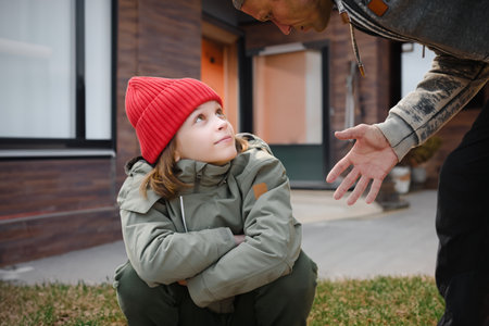 Adult father giving advice to his teenage son outdoor, boy listening to him attentively, Fatherly counsel: Teenage son listens attentively as his father provides valuable guidance outdoors.の写真素材