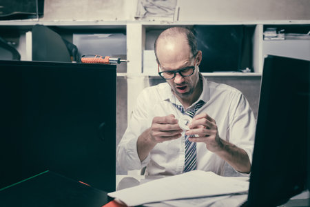 Portrait of sad nervous office manager using adhesive tape after injury, Male attempting computer...