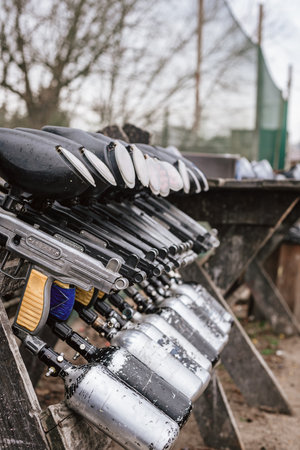 Row of paintball shotguns for conducting tactical battles, closeup photo. Paintball arsenal: Array of paintball weapons lined up in a row, ready for actionの写真素材