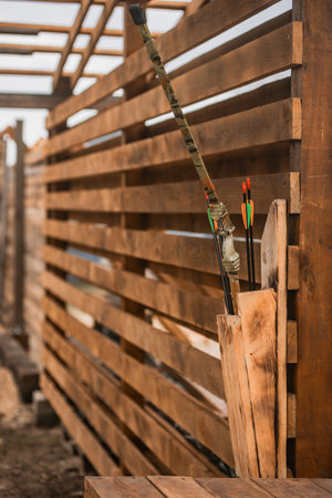 Training arrows hanging on wooden stand on shooting range. Outdoor target practice: Archery setup...