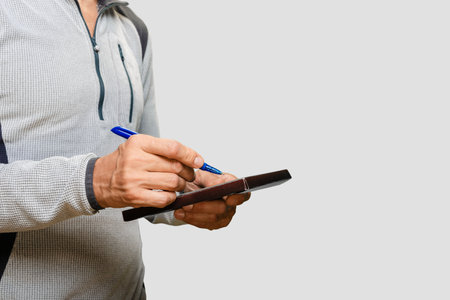 Closeup of male electrician doing meter reading using tabletの写真素材