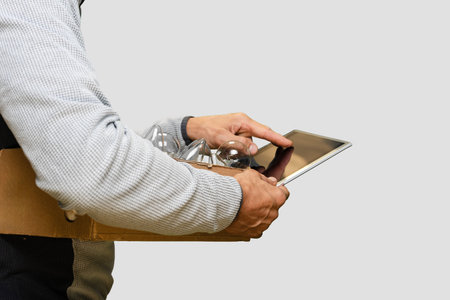Electrician using digital tablet to install light bulb, closeup photo, Man holding an incandescent light bulb, checking power consumption and electricity readings, highlighting energy usageの写真素材