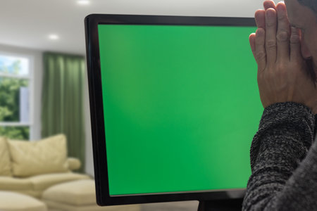 Closeup of upset depressed man searching problem solution and praying during work. Frustrated man at a computer monitor with a chromakey background, showcasing the emotional struggle with tech issuesの写真素材