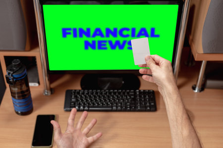 Shocked man with credit card receiving notification about online money transfer. Financial news on monitor, man showing emotions, hands on keyboardの写真素材