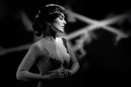 Monochrome fashion portrait of beautiful sensual woman with curly hair. Retro-themed black and white portrait with studio light, wave hair, and serene expressionの写真素材