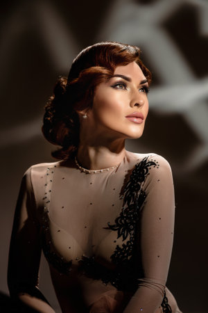 Attractive lady with old fashioned makeup and finger wave hairstyle. Retro fashion girl posing in transparent blouse with vintage hairstyle and moody lightingの写真素材