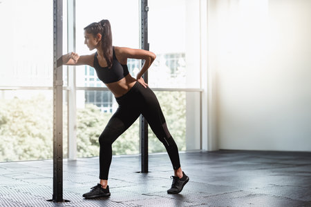Young beautiful sporty woman working out alone in fitness gym, Brunette girl alone in gym, workout session with copy spaceの写真素材
