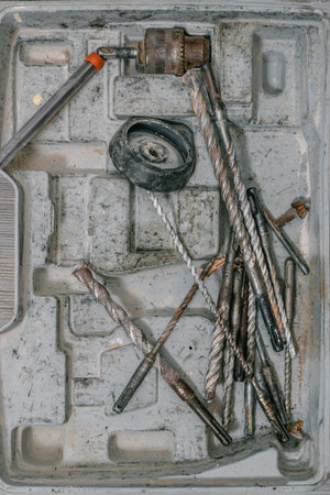 Closeup photo of storage case with variety of bits for drill. Old drills neatly arranged in a box, top view, vintage tools for repair and construction work.の写真素材