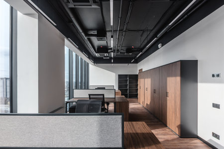 Part of ordinary office room decorated in modern style. Executive office with wooden desk and...