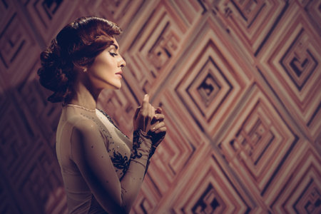 Young luxury woman in retro vintage style, profile side view. Glamour portrait of woman with hand on head in retro dressの写真素材