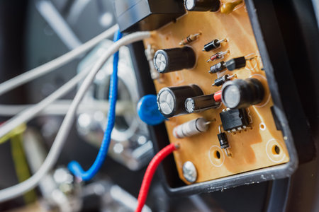 Disassembled broken electric multicooker with wires and capacitor, closeup photo. Close-up of motherboard inside opened multicookerの写真素材