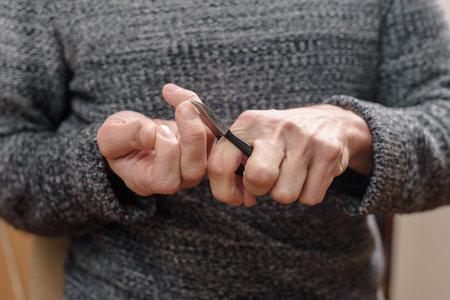 Closeup photo of man cutting nails with clippers by himself Male nail care as part of regular...