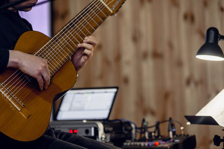 Hands of male artist playing the electric guitar, closeup photo Professional musician playing...