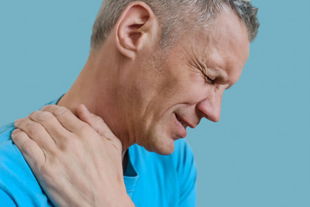 Portrait of adult man with office syndrome backache suffering from muscles pain. Man grimaces in...
