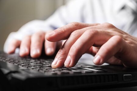 Close-up young man fingers on a computer keyboard.