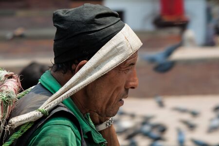 KATMANDU, NEPAL -  APRIL 15 2013: Nepali man with a basket for carrying heavy loads on their heads.のeditorial素材
