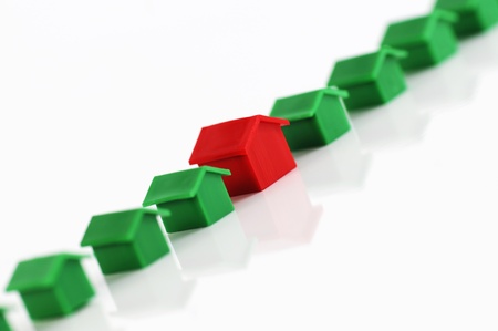 Muenster, Germany - April 10, 2010: Row of red and green plastic houses from the famous property trading board game Monopoly, isolated on white. Monopoly is owned and manufactured by Hasbro.のeditorial素材