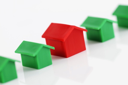 Muenster, Germany - April 10, 2010: Row of red and green plastic houses from the famous property trading board game Monopoly, isolated on white. Monopoly is owned and manufactured by Hasbro.のeditorial素材