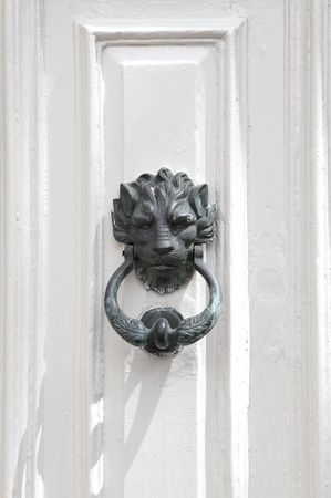 Bronze lion door knocker on white door in Mdina, Malta 