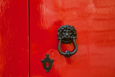 Old red door with lion head metal knockers, Mdina, Malta.の写真素材