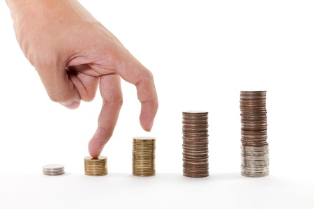 Fingers walking up on stacks of coins on white backgroundの写真素材
