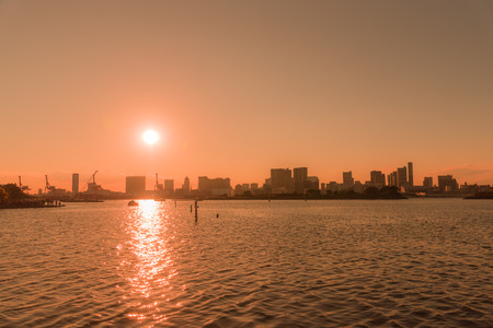 Silhouette of building with river and sunset at Odaiba Japan, blurred and low keyの写真素材