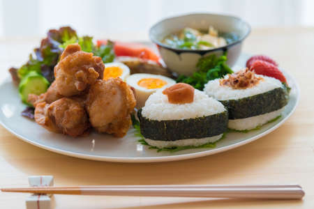 The image of breakfast. Onigiri and fried chicken plate.の写真素材