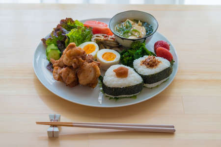 The image of breakfast. Onigiri and fried chicken plate.の写真素材