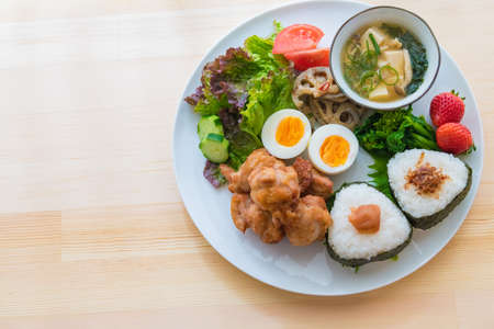 The image of breakfast. Onigiri and fried chicken plate.の写真素材